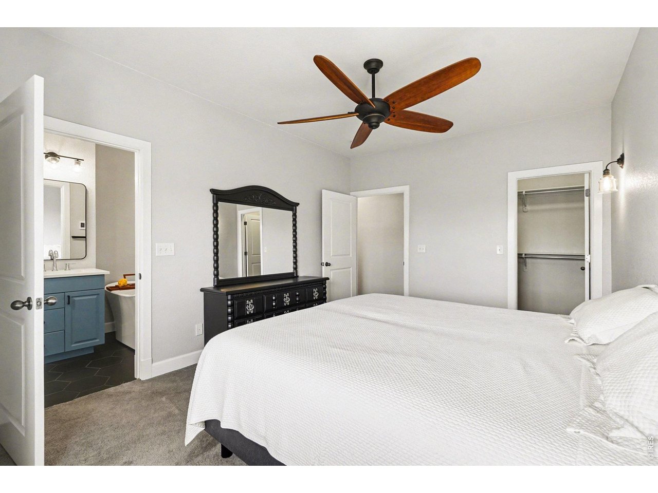 844 Cliffrose Way Severance, CO 80550 - Photo 17 of 50 a bedroom with a large bed and a chandelier
