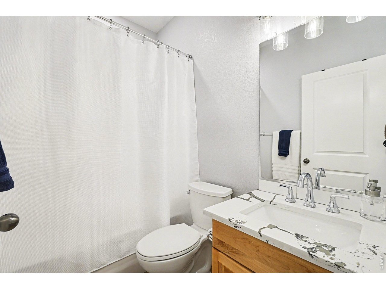 844 Cliffrose Way Severance, CO 80550 - Photo 28 of 50 a bathroom with a granite countertop sink toilet and a mirror