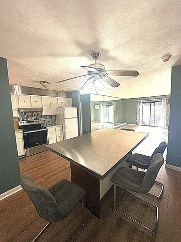 a living room with a table chairs and a kitchen view