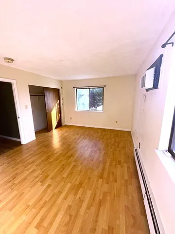 a view of empty room with wooden floor