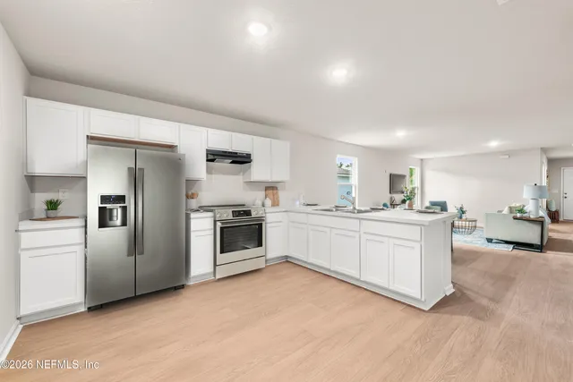 a kitchen with white cabinets and stainless steel appliances