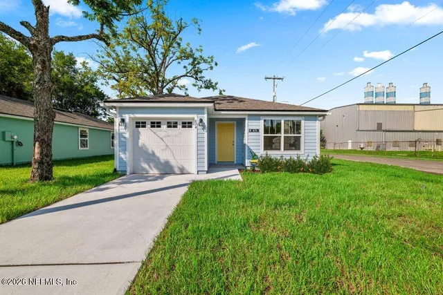 a view of a house with a yard and a garage