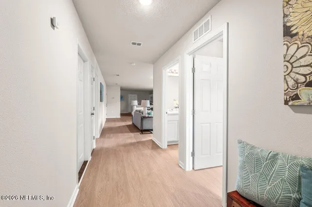 a view of a bedroom with wooden floor and a bathroom