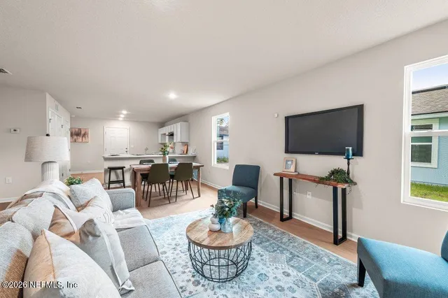 a living room with furniture a flat screen tv and a large window