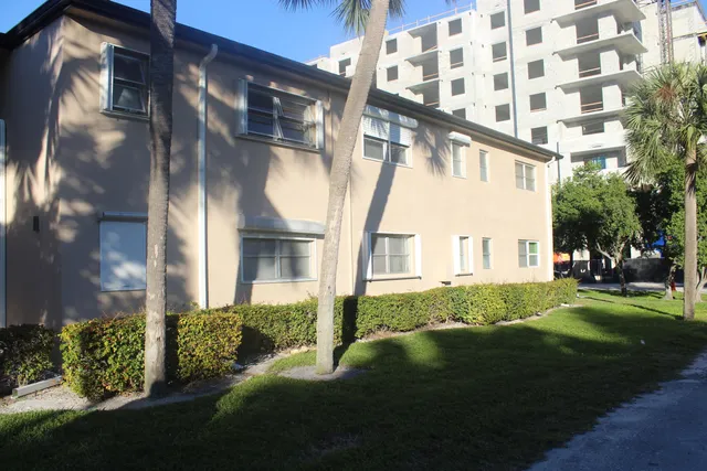 a front view of a building with a garden