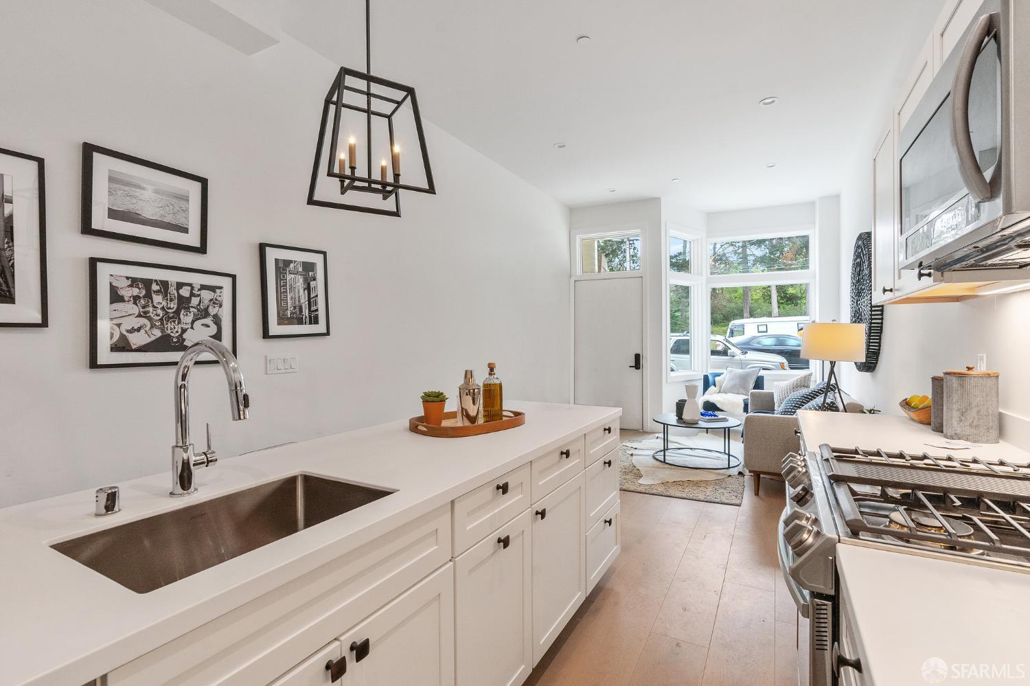 3036 Fulton Street, Unit 1 San Francisco, CA 94118 - Photo 5 of 13 a kitchen with a sink dishwasher a stove and white cabinets with wooden floor