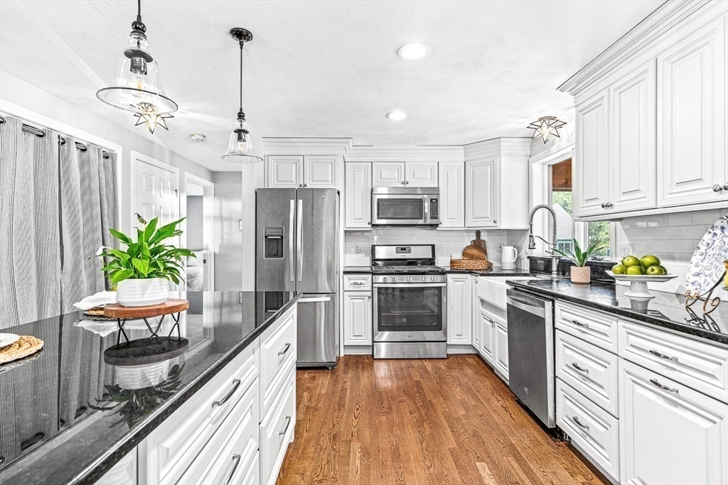 27 A Andrews Farm Road Boxford, MA 01921 - Photo 12 of 37 a kitchen with kitchen island granite countertop a refrigerator a stove a sink dishwasher a oven with white cabinets and wooden floor