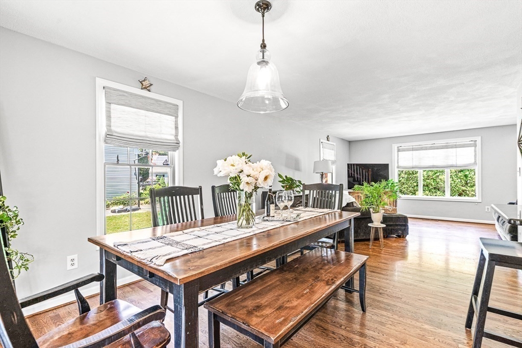 27 A Andrews Farm Road Boxford, MA 01921 - Photo 14 of 37 a dining room with wooden floor a chandelier a wooden table and chairs
