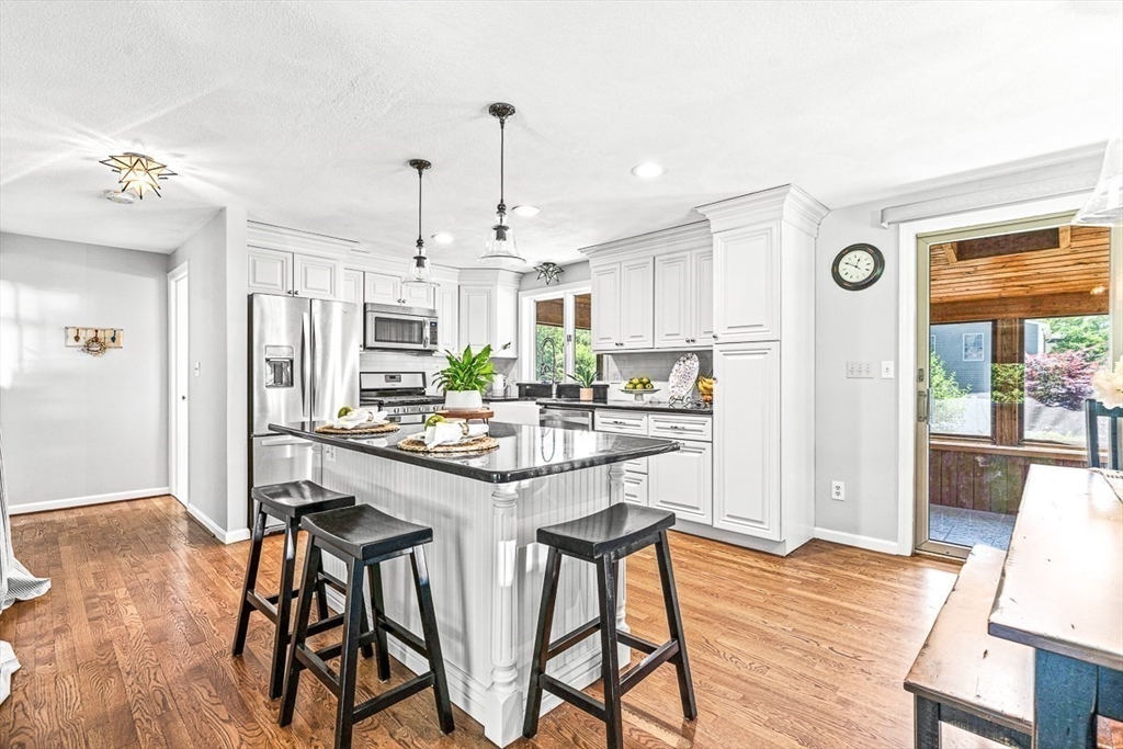 27 A Andrews Farm Road Boxford, MA 01921 - Photo 9 of 37 a kitchen with stainless steel appliances a dining table chairs and wooden floor