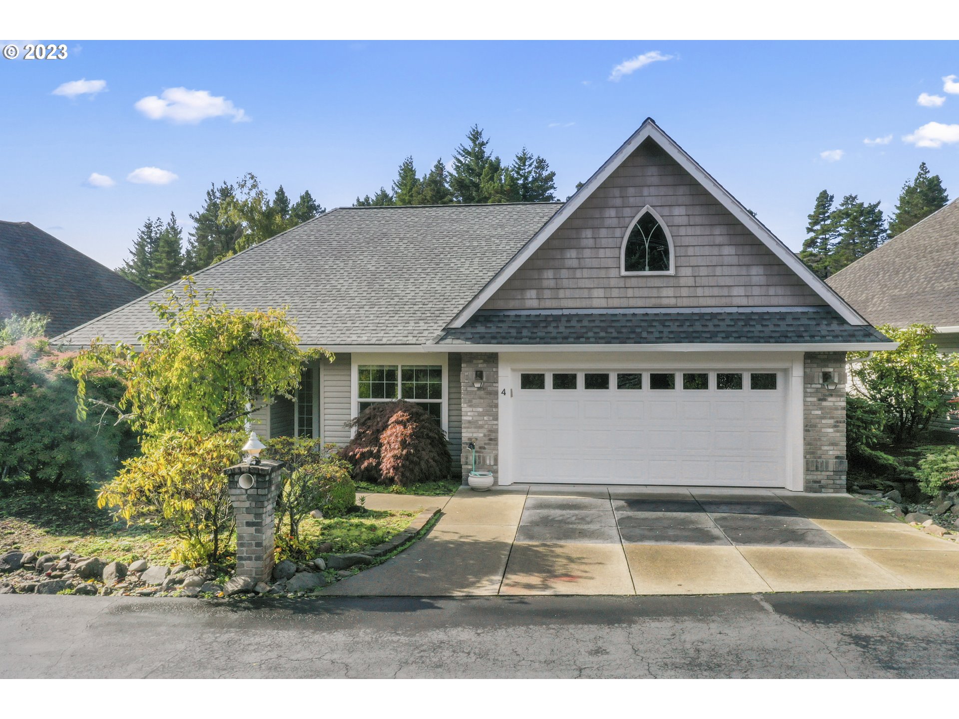 a view of a house with a yard and potted plants