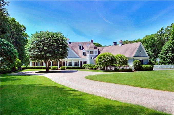 a front view of a house with a yard and trees