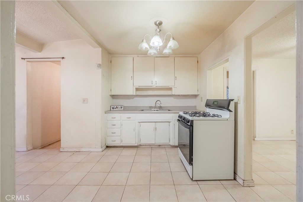 10180 Eddystone Street Riverside, CA 92503 - Photo 22 of 34 a kitchen with a stove sink and cabinets