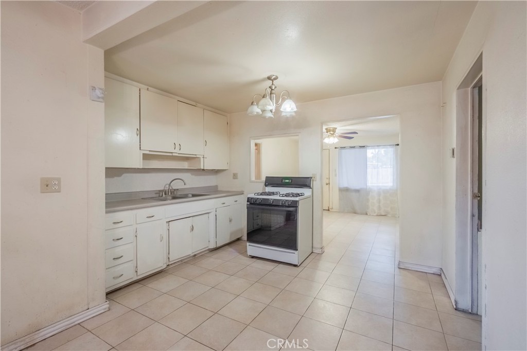 10180 Eddystone Street Riverside, CA 92503 - Photo 27 of 34 a large kitchen with a stove top oven sink and cabinets