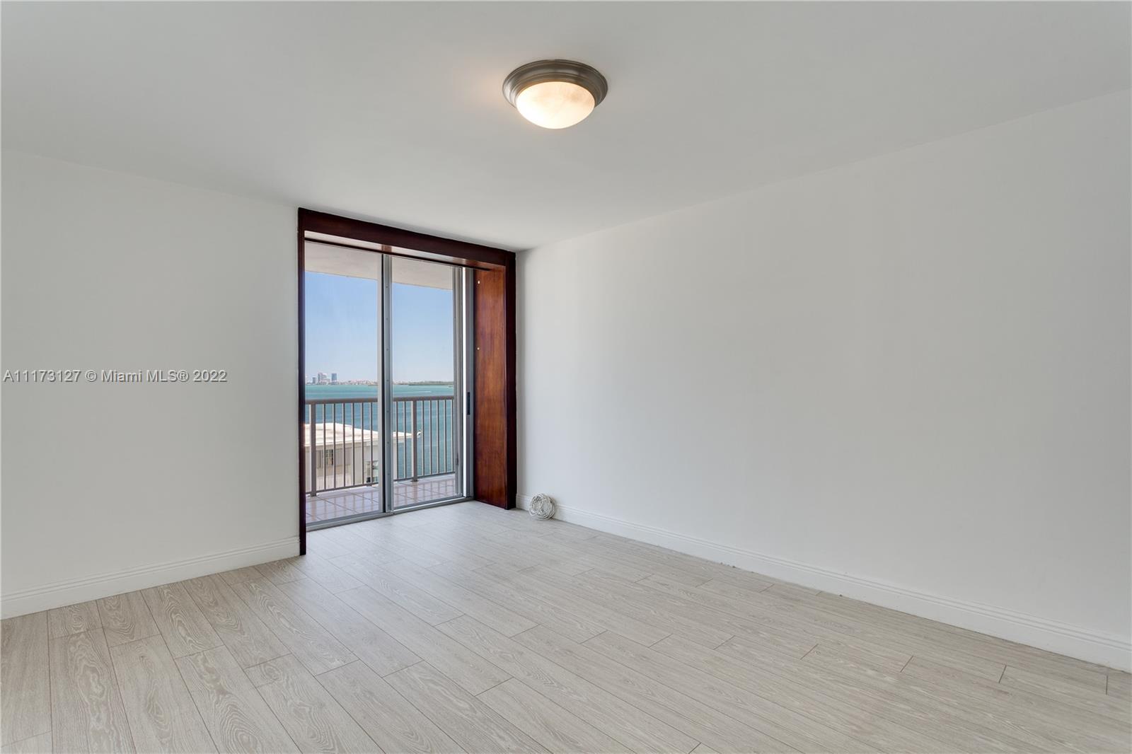 150 Southeast 25th Road, Unit PHA Miami, FL 33129 - Photo 18 of 24 a view of an empty room with wooden floor and a window