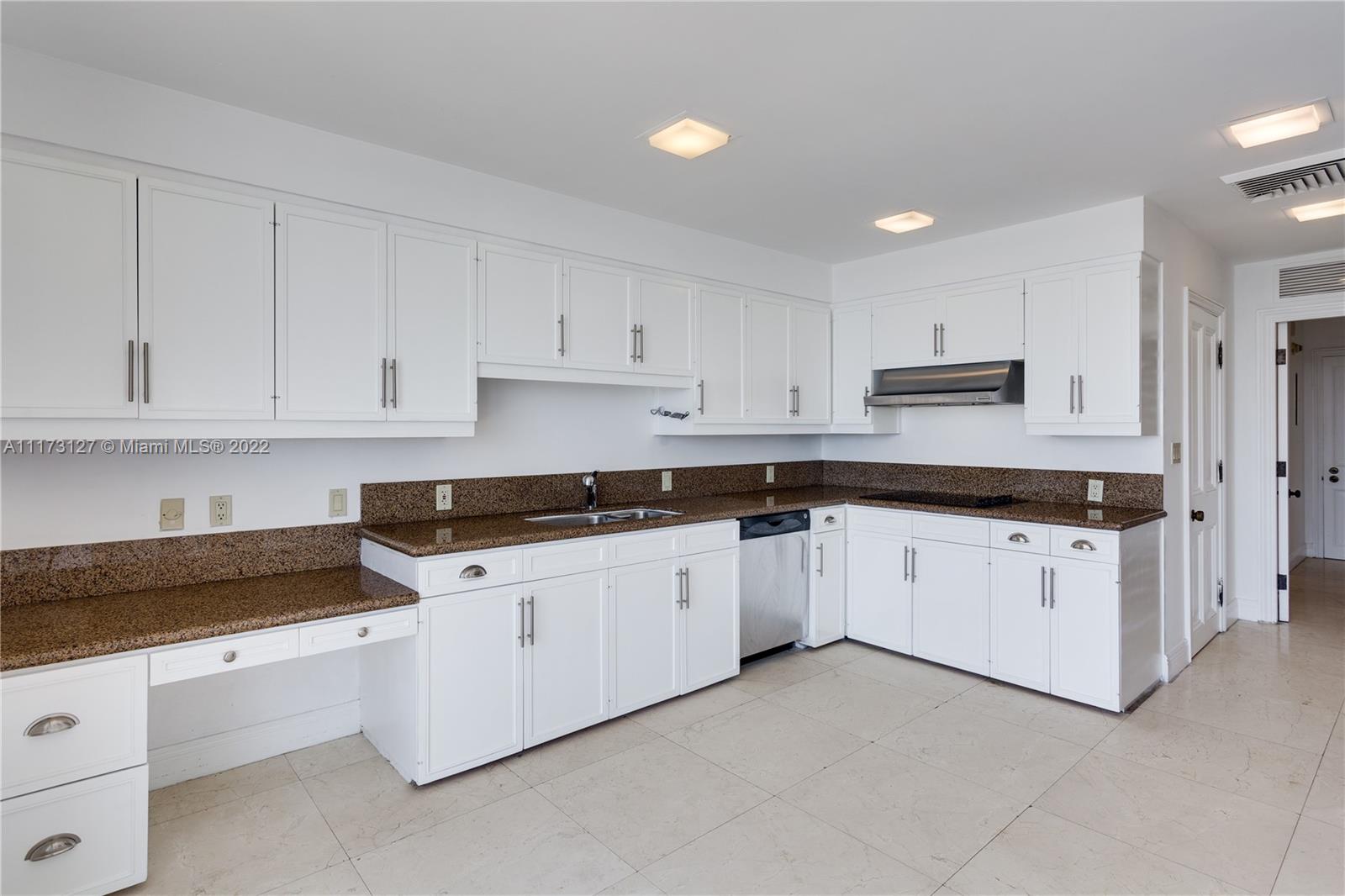 150 Southeast 25th Road, Unit PHA Miami, FL 33129 - Photo 8 of 24 a kitchen with granite countertop white cabinets and white appliances