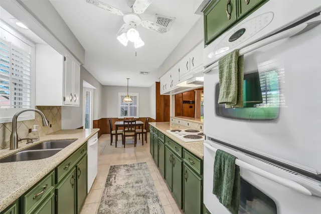 a kitchen with stainless steel appliances granite countertop a sink stove and cabinets