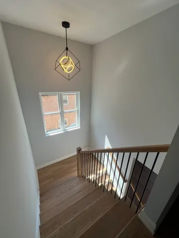 a view of a hallway with wooden floor and a window