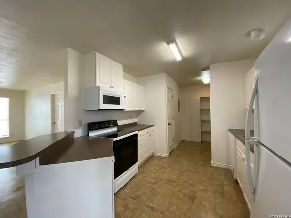 a kitchen with granite countertop a refrigerator stove and sink