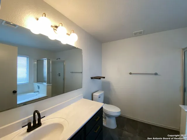 a bathroom with a sink a toilet and mirror