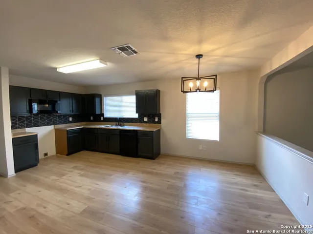 a large kitchen with stainless steel appliances granite countertop a sink counter space and wooden floor