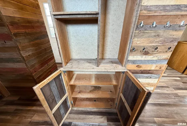 a view of empty room with wooden floor and door