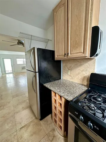 a kitchen with granite countertop a sink stove and refrigerator