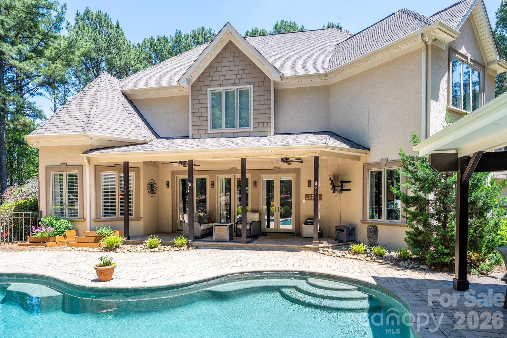 7315 Bay Ridge Drive Denver, NC 28037 - Photo 5 of 39 a view of a house with patio chairs and couches chairs under an umbrella