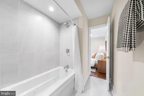 a bathroom with a tub shower and sink