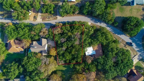 an aerial view of residential house with outdoor space and trees all around