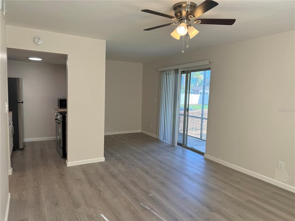 5521 Bay Boulevard, Unit 105 Port Richey, FL 34668 - Photo 3 of 15 a view of an empty room with window and wooden floor