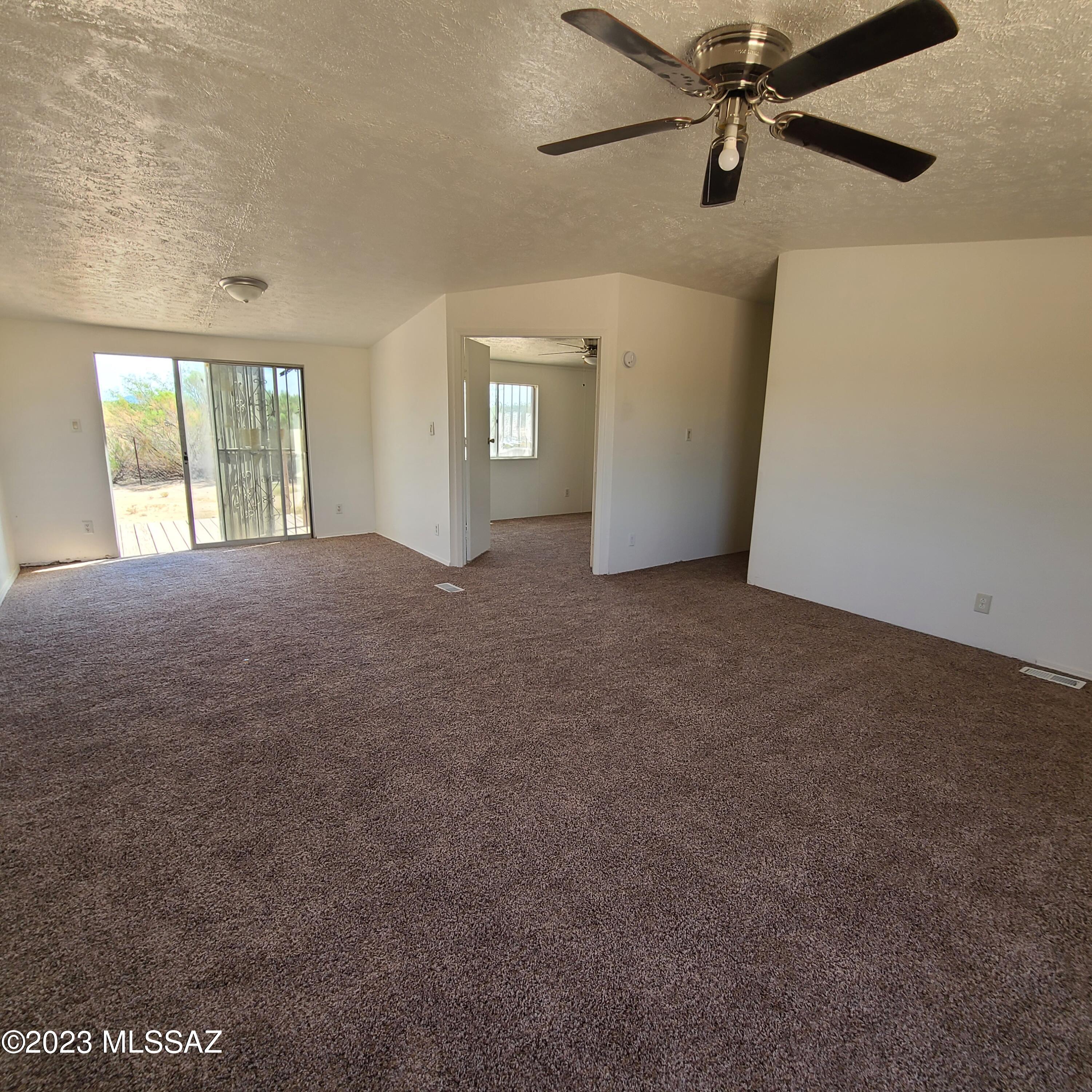 8896 South Marstellar Road Tucson, AZ 85736 - Photo 8 of 39 an empty room with windows and ceiling fan