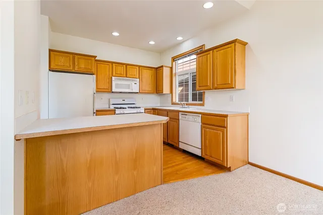 a kitchen with stainless steel appliances granite countertop a sink a stove and a refrigerator