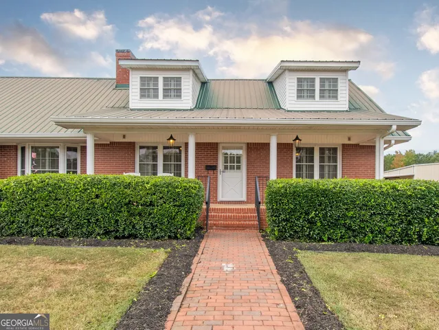 front view of a brick house with a yard