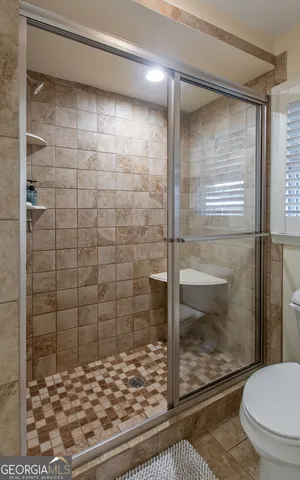 a bathroom with a toilet and a shower