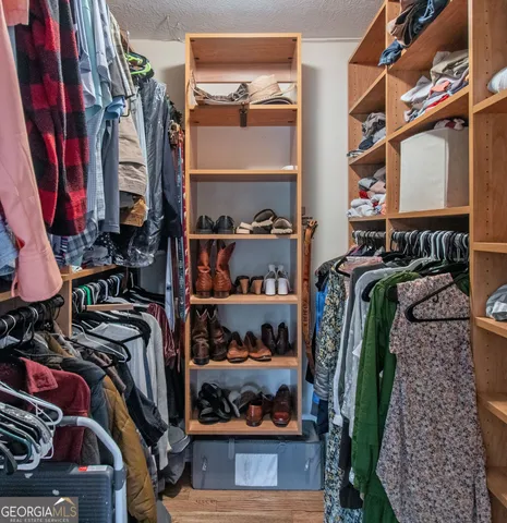 a view of walk in closet with clothes and shoes