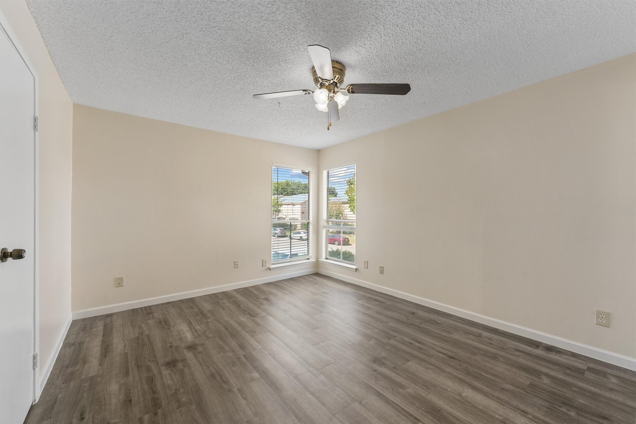 9221 Imogene Street, Unit 9221 Houston, TX 77036 - Photo 4 of 19 an empty room with wooden floor fan and windows