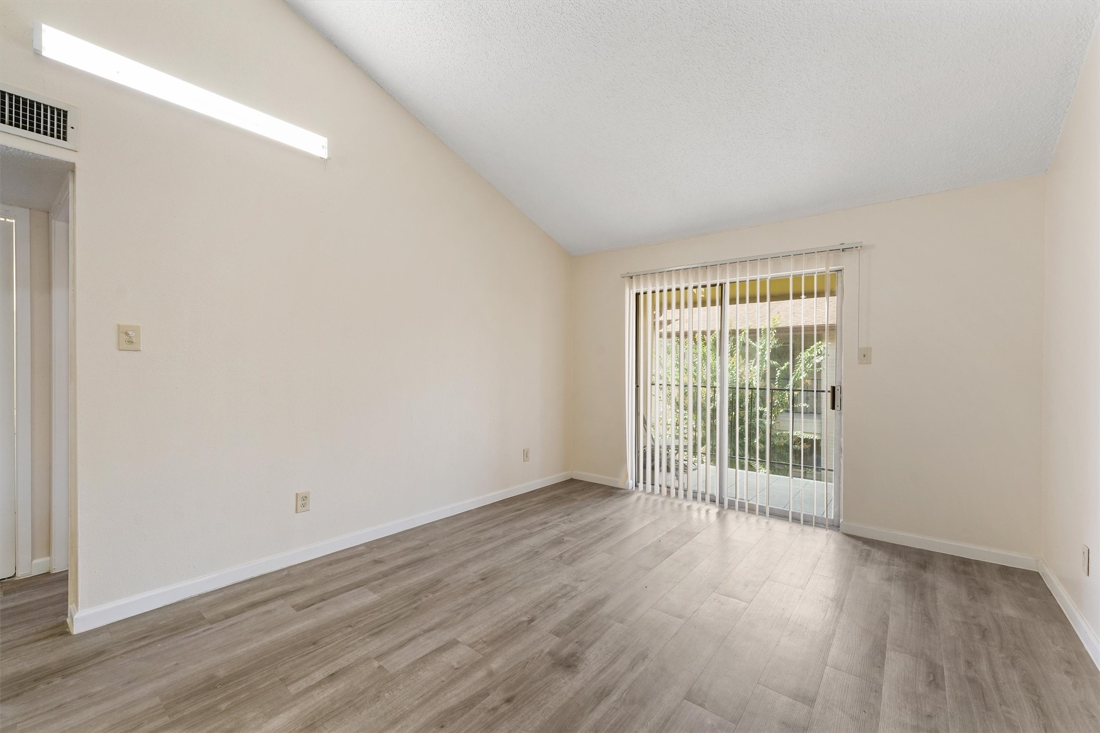 9221 Imogene Street, Unit 9221 Houston, TX 77036 - Photo 8 of 19 an empty room with wooden floor and windows
