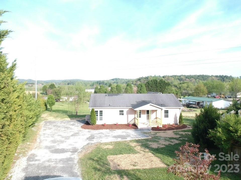 2240 Pace Road Hendersonville, NC 28792 - Photo 2 of 23 a view of a white house with a big yard plants and large trees