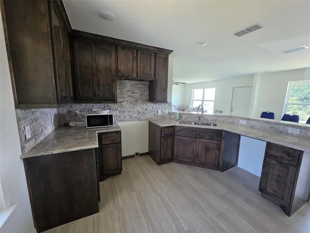 a kitchen with stainless steel appliances granite countertop wooden cabinets sink and stove