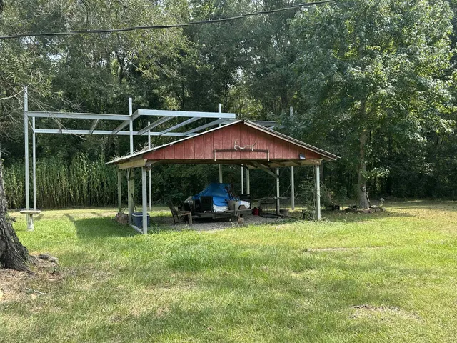 a view of backyard with table and chairs under an umbrella