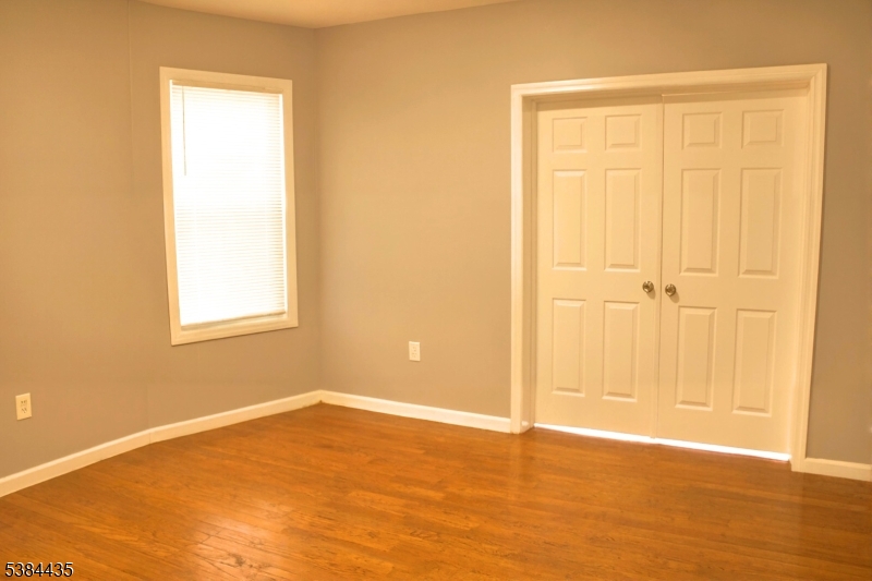 104 South 12th Street, Unit 3 Newark, NJ 07107 - Photo 11 of 12 an empty room with wooden floor and closet area