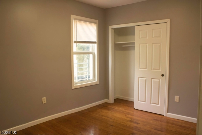 104 South 12th Street, Unit 3 Newark, NJ 07107 - Photo 9 of 12 an empty room with wooden floor closet and windows