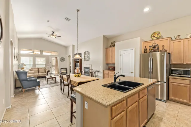 a kitchen with a sink a counter and chairs