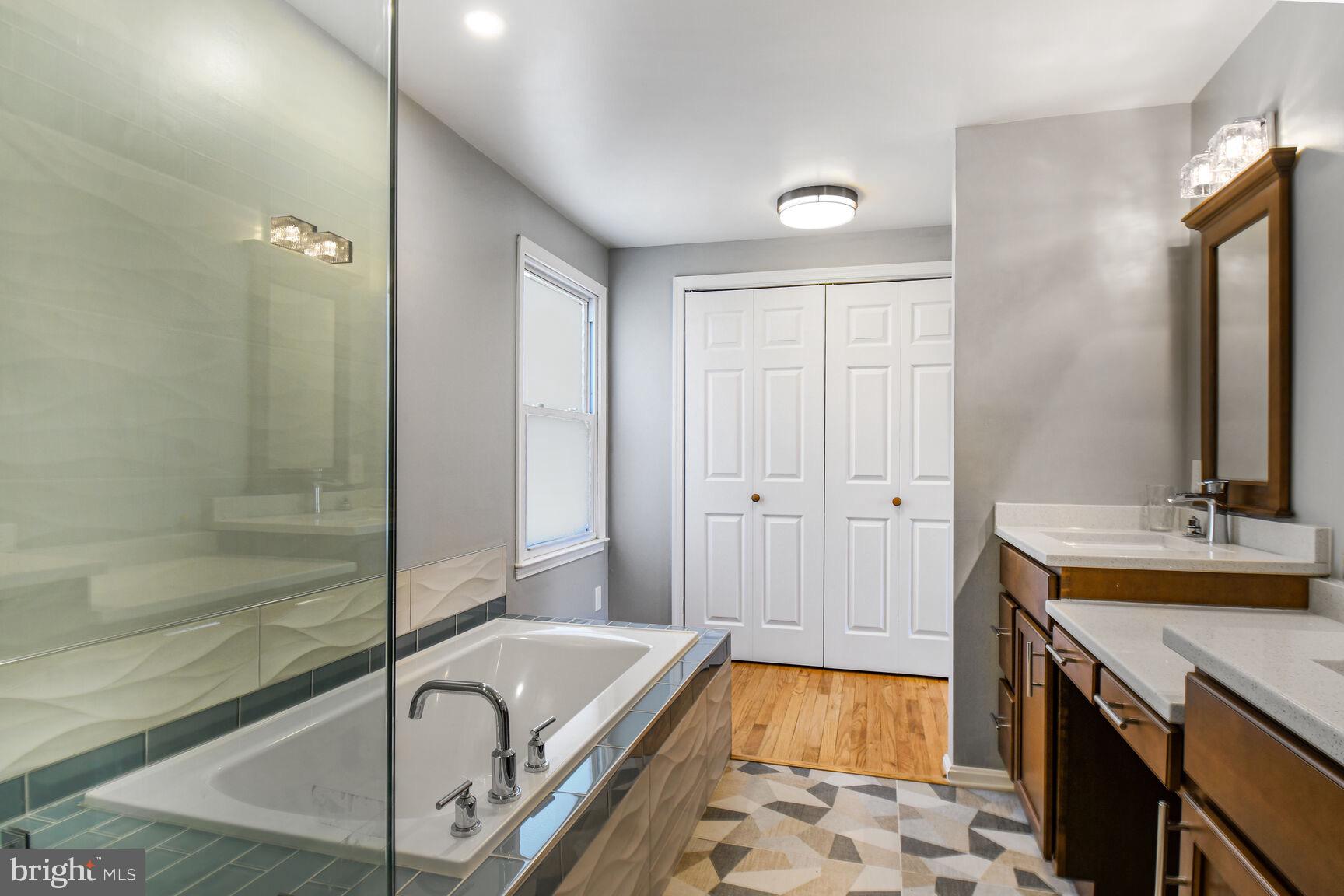 15320 Baileys Lane Silver Spring, MD 20906 - Photo 18 of 28 a bathroom with a tub a double vanity sink and a mirror
