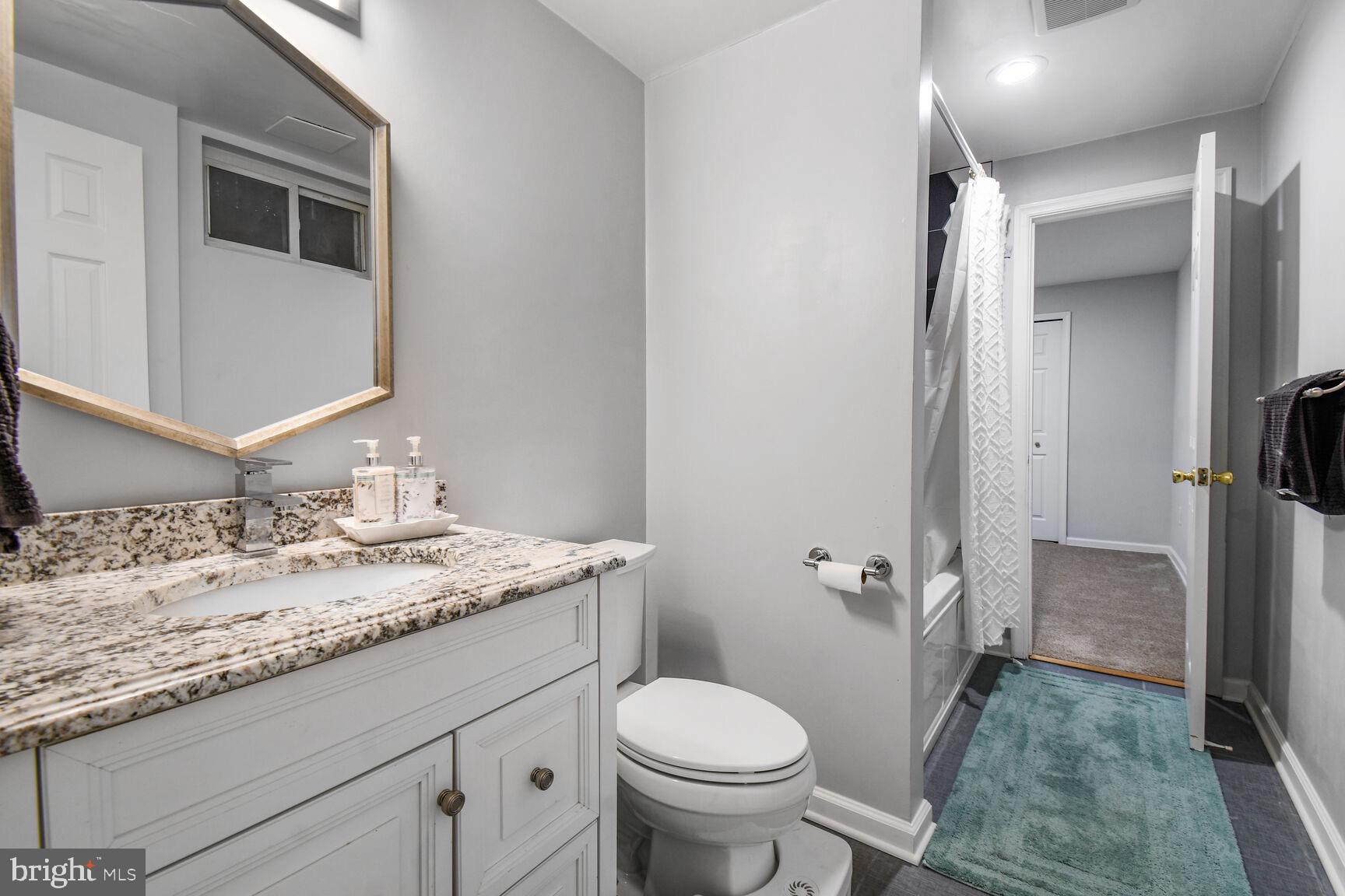 15320 Baileys Lane Silver Spring, MD 20906 - Photo 21 of 28 a bathroom with a granite countertop sink toilet and shower