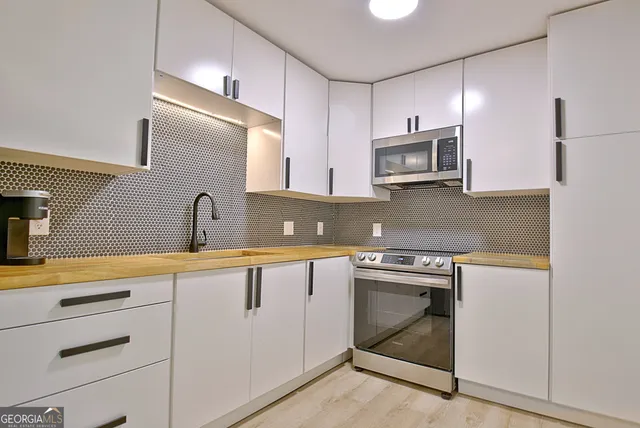 a kitchen with stainless steel appliances a sink stove and refrigerator