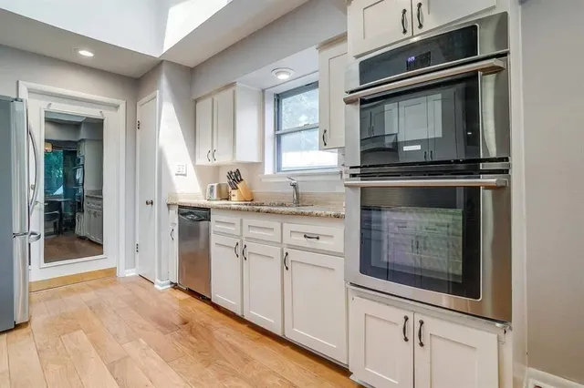 a kitchen with stainless steel appliances granite countertop a sink and cabinets