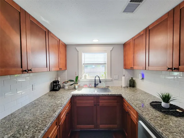 a kitchen with stainless steel appliances granite countertop a refrigerator a stove and a wooden cabinets
