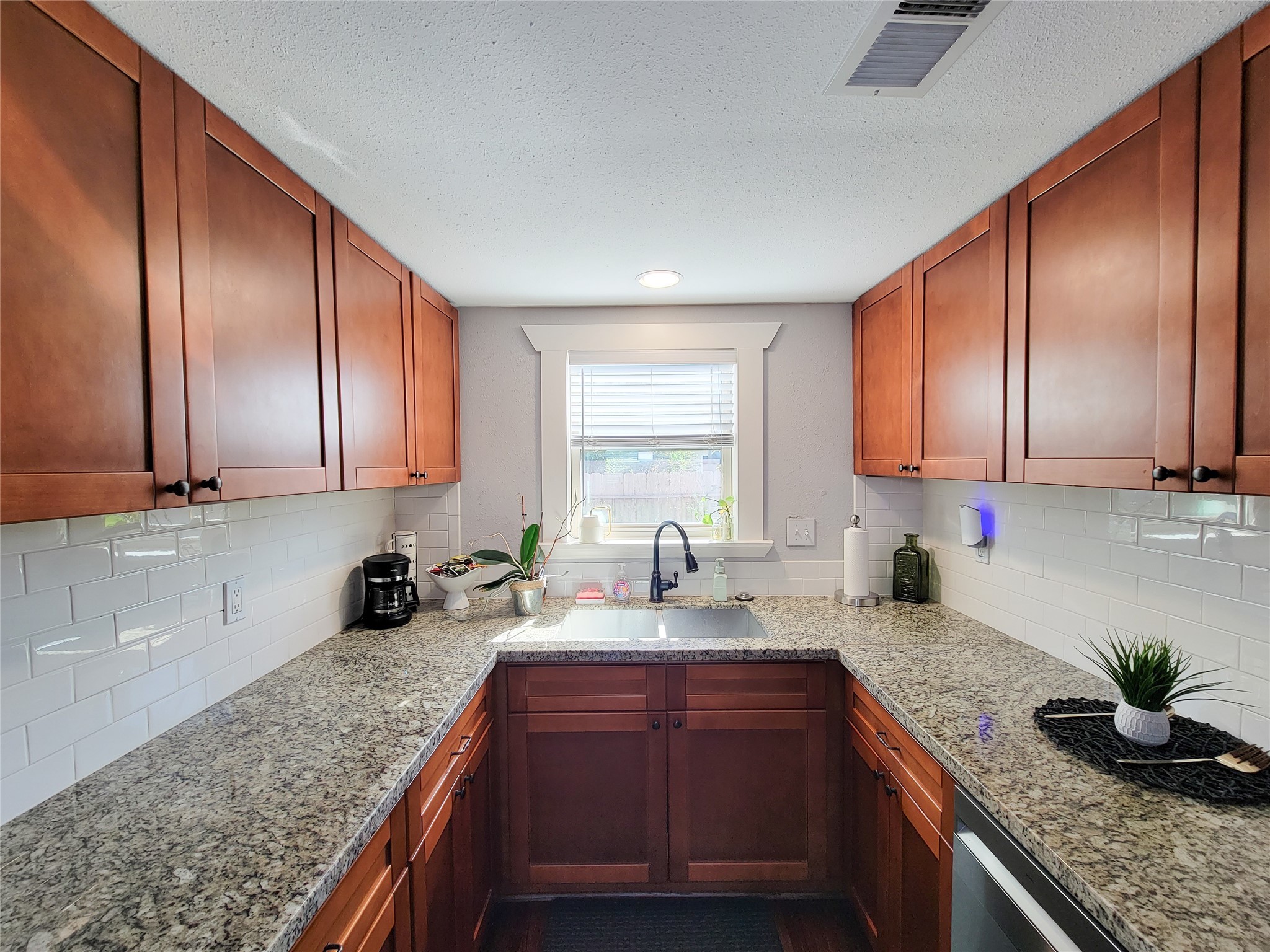 2604 Cochran Street Houston, TX 77009 - Photo 13 of 35 a kitchen with granite countertop wooden cabinets a sink and dishwasher stove with wooden floor