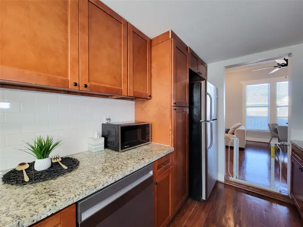 a kitchen with stainless steel appliances granite countertop a refrigerator a stove and a wooden cabinets